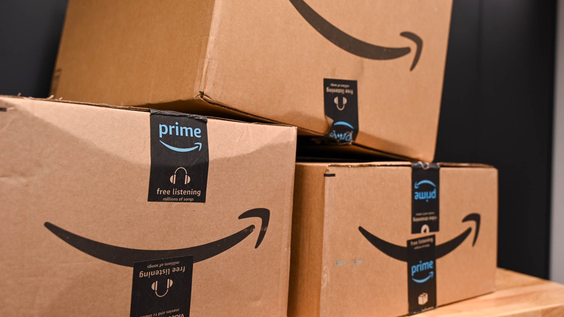 Amazon packages stacked on a workbench.