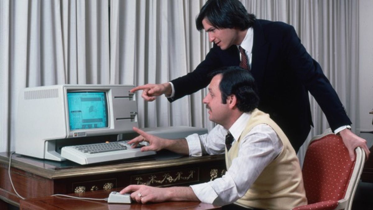 Photo of the Lisa computer on a desk, Steve Jobs and John Couch are in front