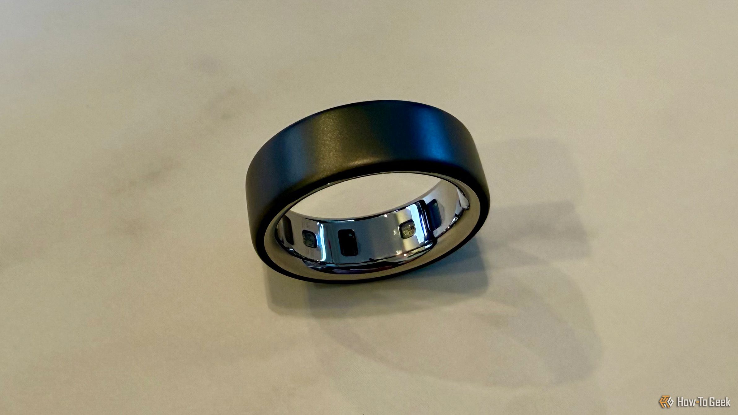 Oura Ring 4 on a table top showing the interior sensors.