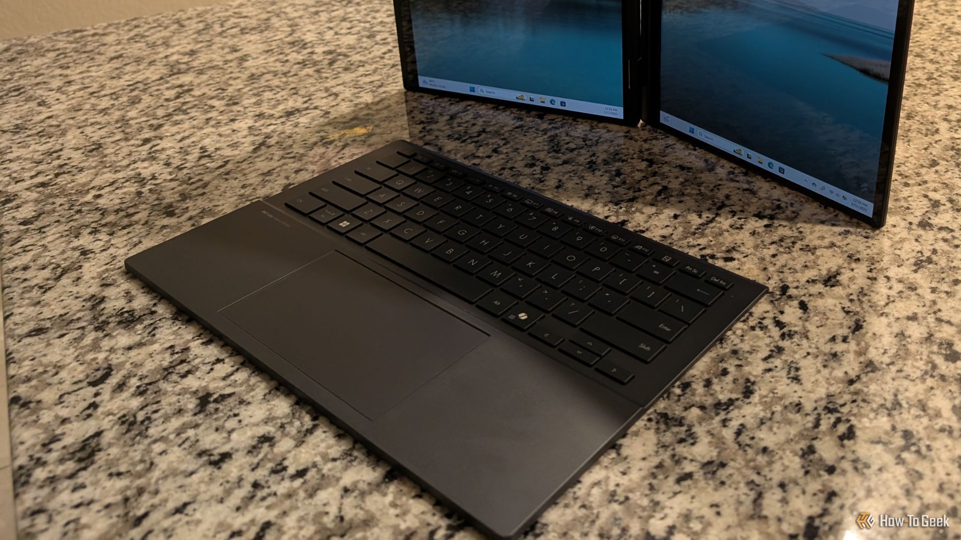 ASUS Zenbook Duo Keyboard in front of vertically standing displays.