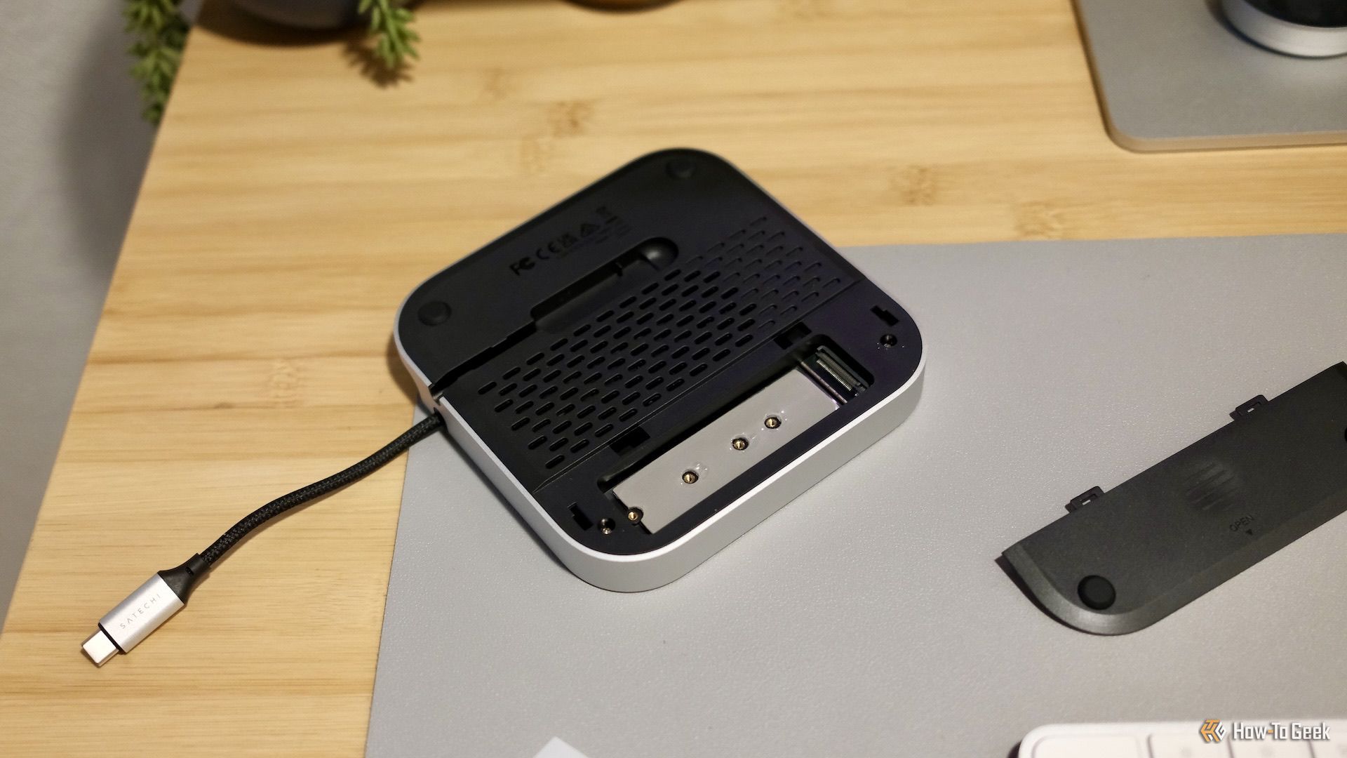 Satechi Mac Mini M4 Stand & Hub shown upside down with the SSD slot exposed.