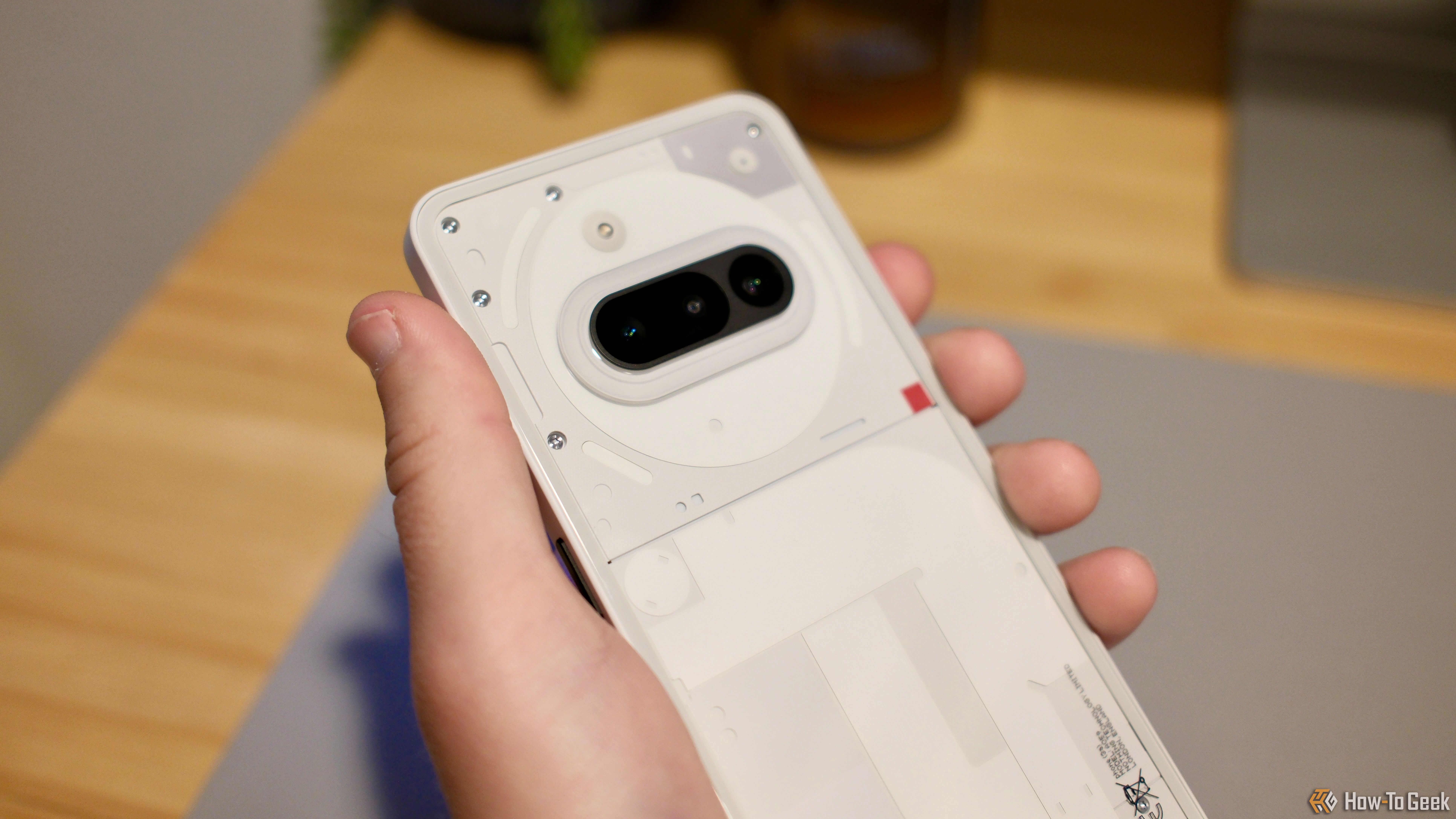 A hand holding the Nothing Phone (3a).