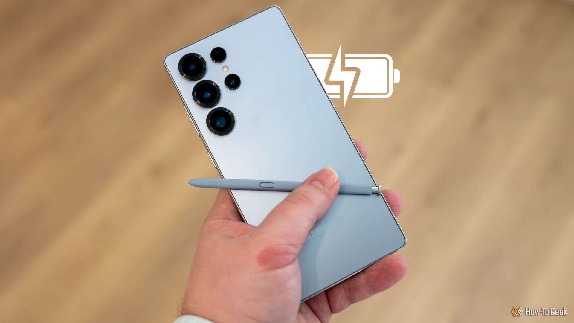 A person holding the Galaxy S25 Ultra showings its back panel and the S Pen.