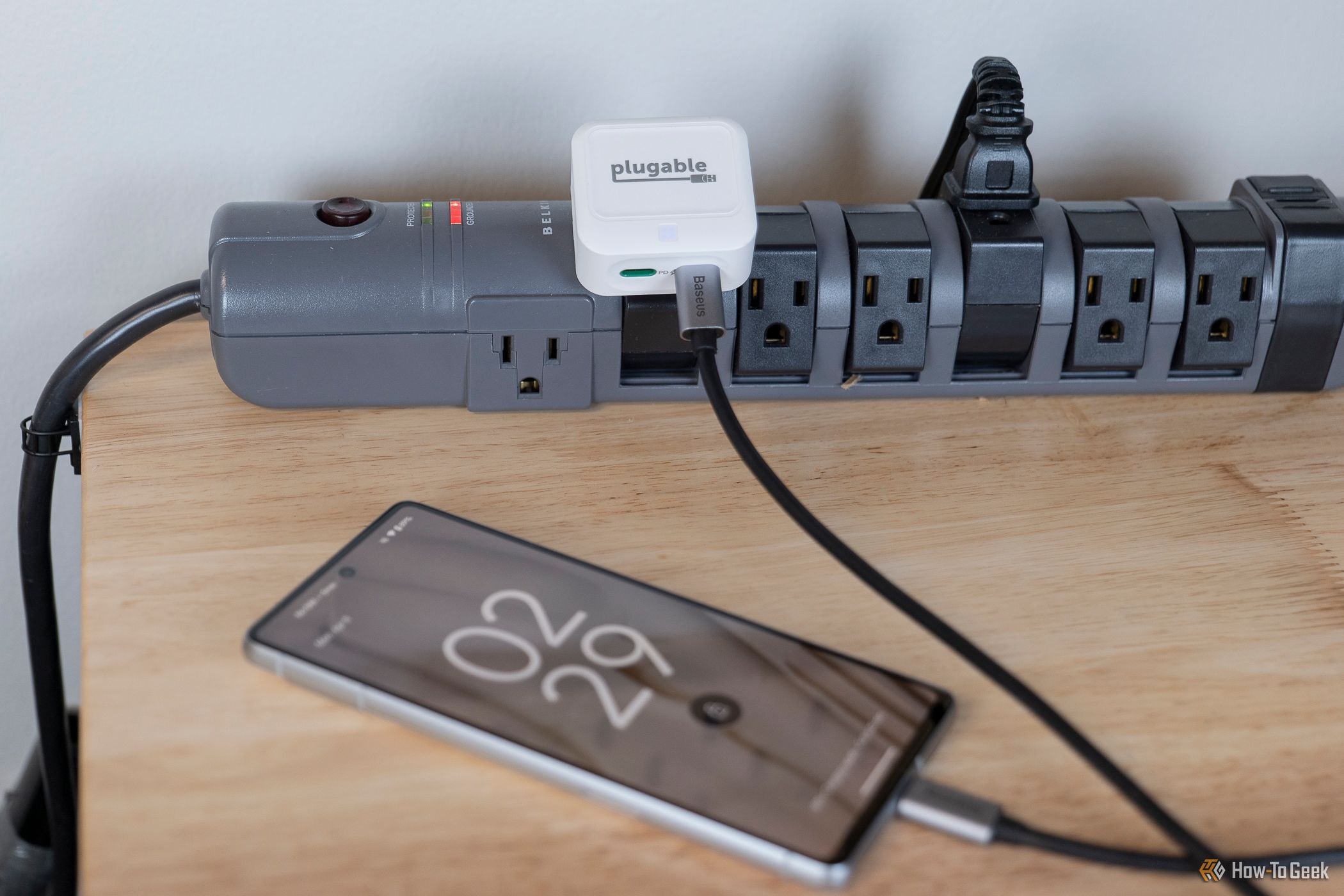 The Plugable 40W Dual USB-C Charger chariging a phone on a table.