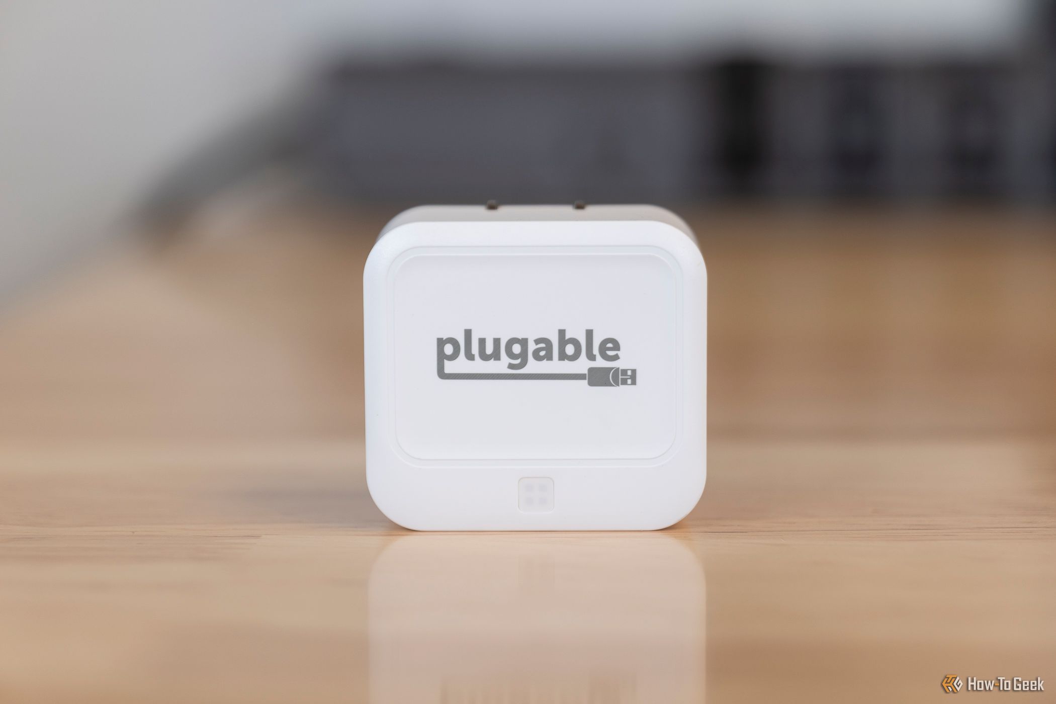 The Plugable 40W Dual USB-C Charger sitting on a table.