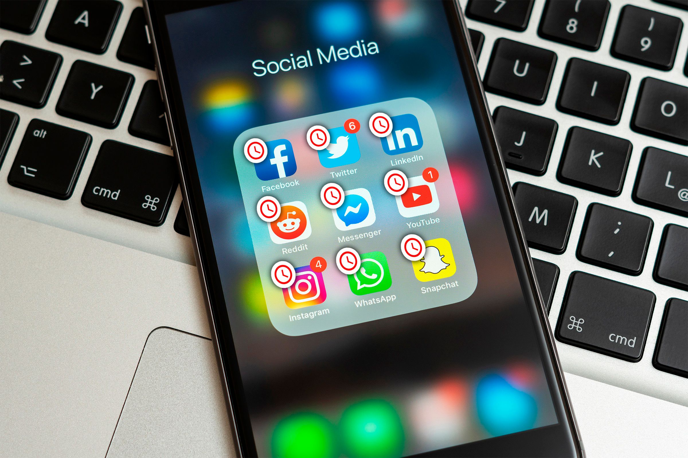 A phone with some social media applications with a clock icon.