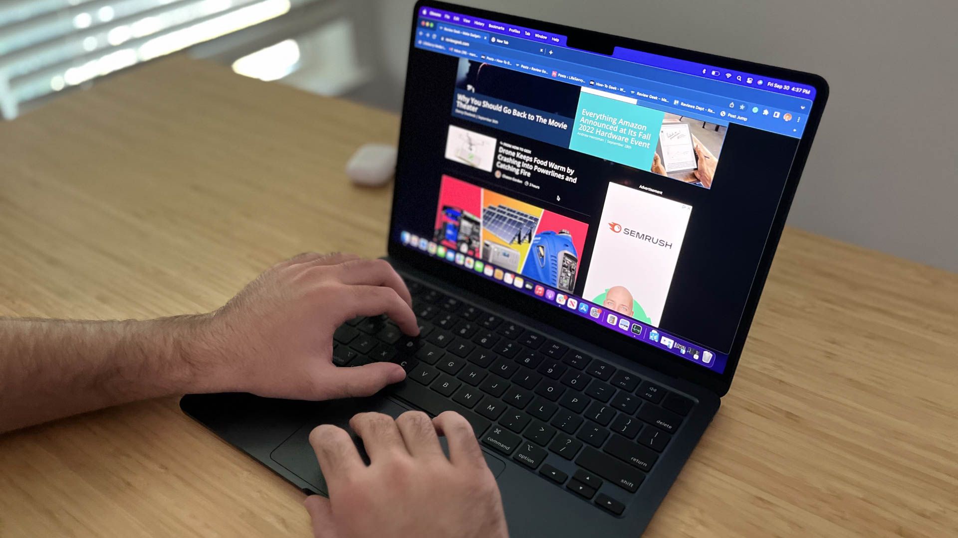 Person typing on a MacBook Air while sitting at a desk.