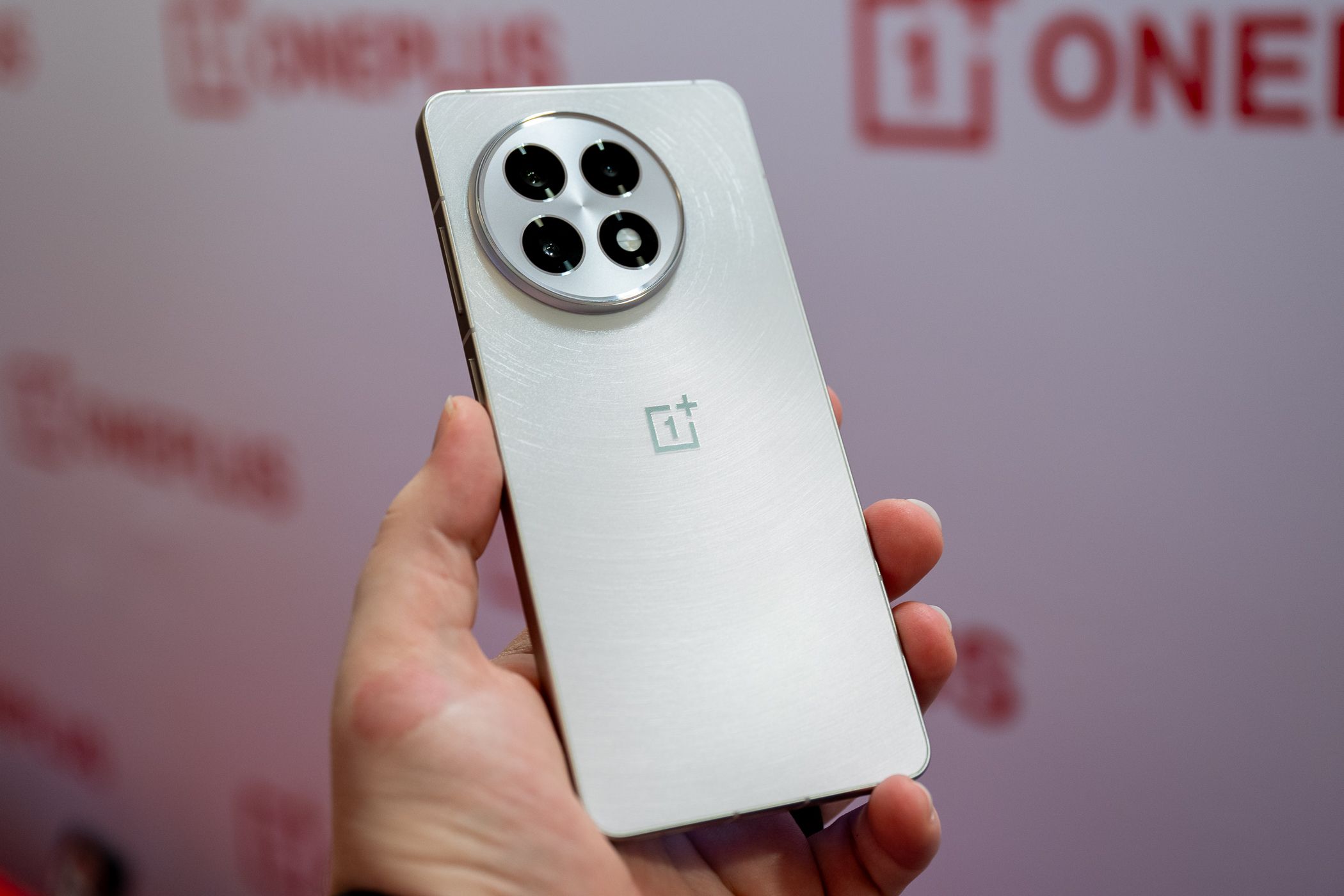 Person holding the OnePlus 13R in white.