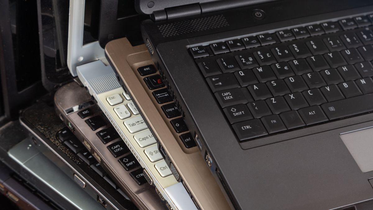 Stack of dusty used laptops.