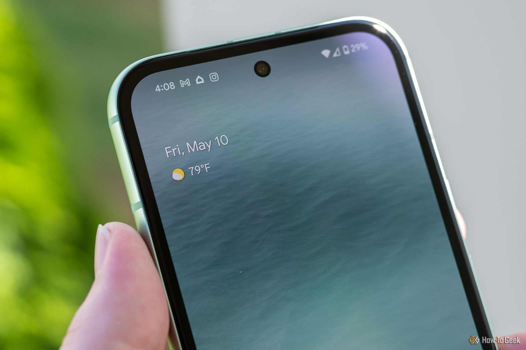 Person holding the Google Pixel 8a showing the front facing camera