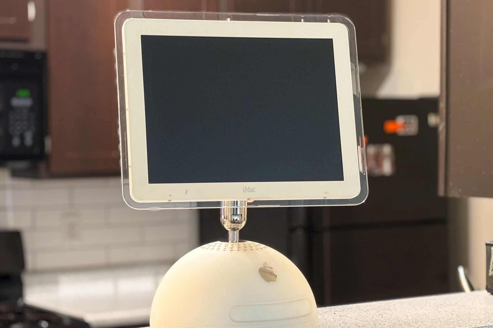 An iMac G4 on a kitchen counter.