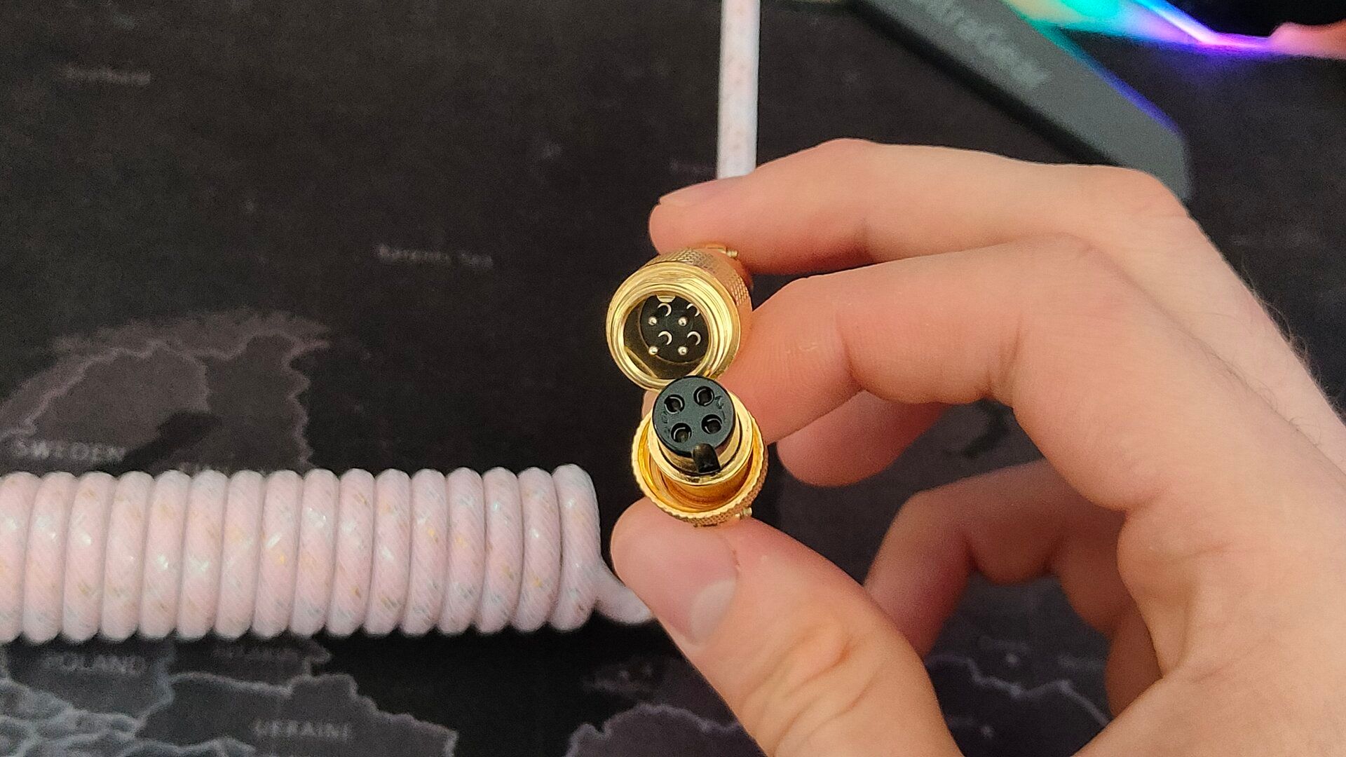 Two sides of a golden aviator connector.