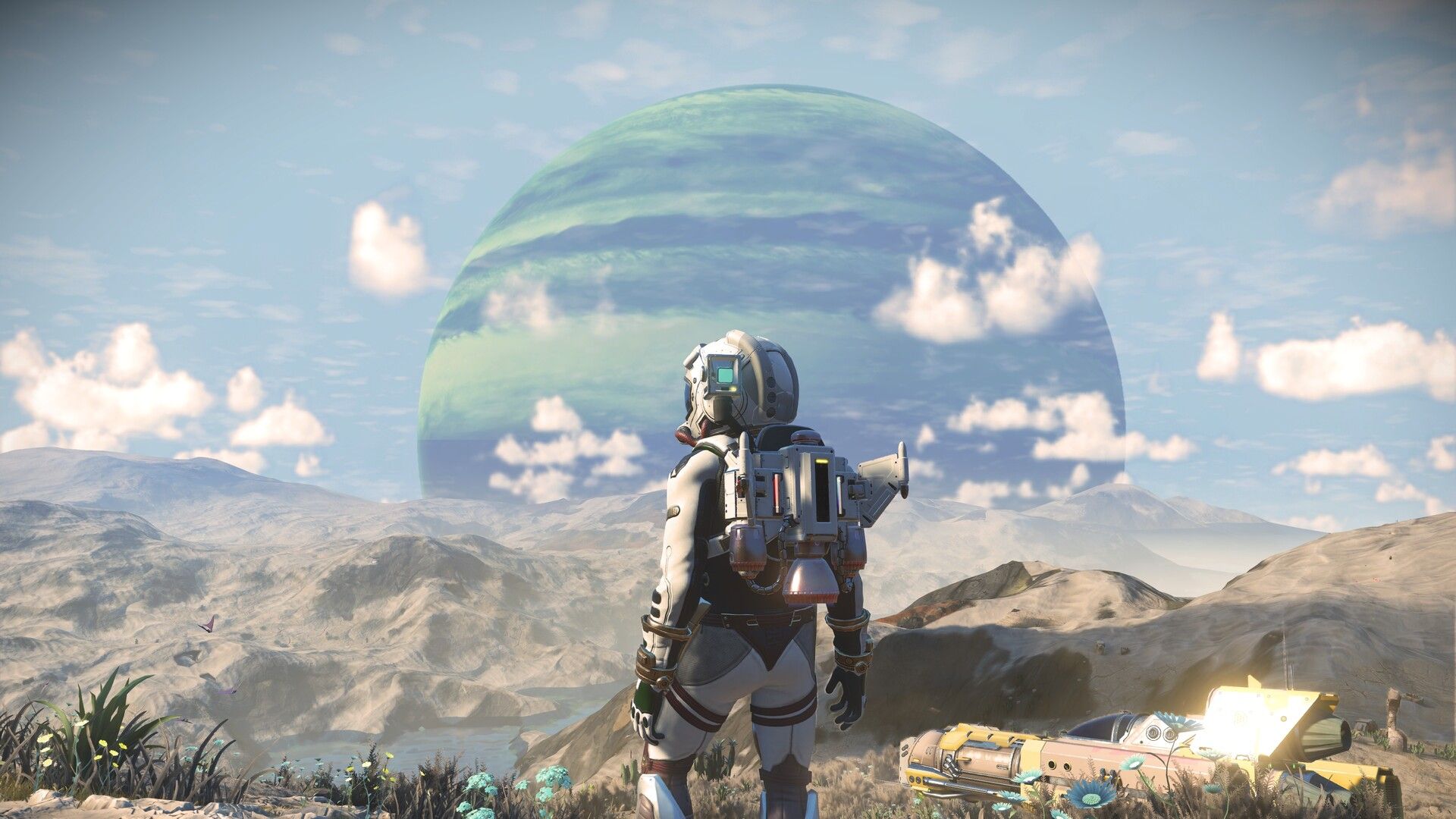 Third person perspective of a character in a space suit overlooking an alien planet in the game No Man's Sky.
