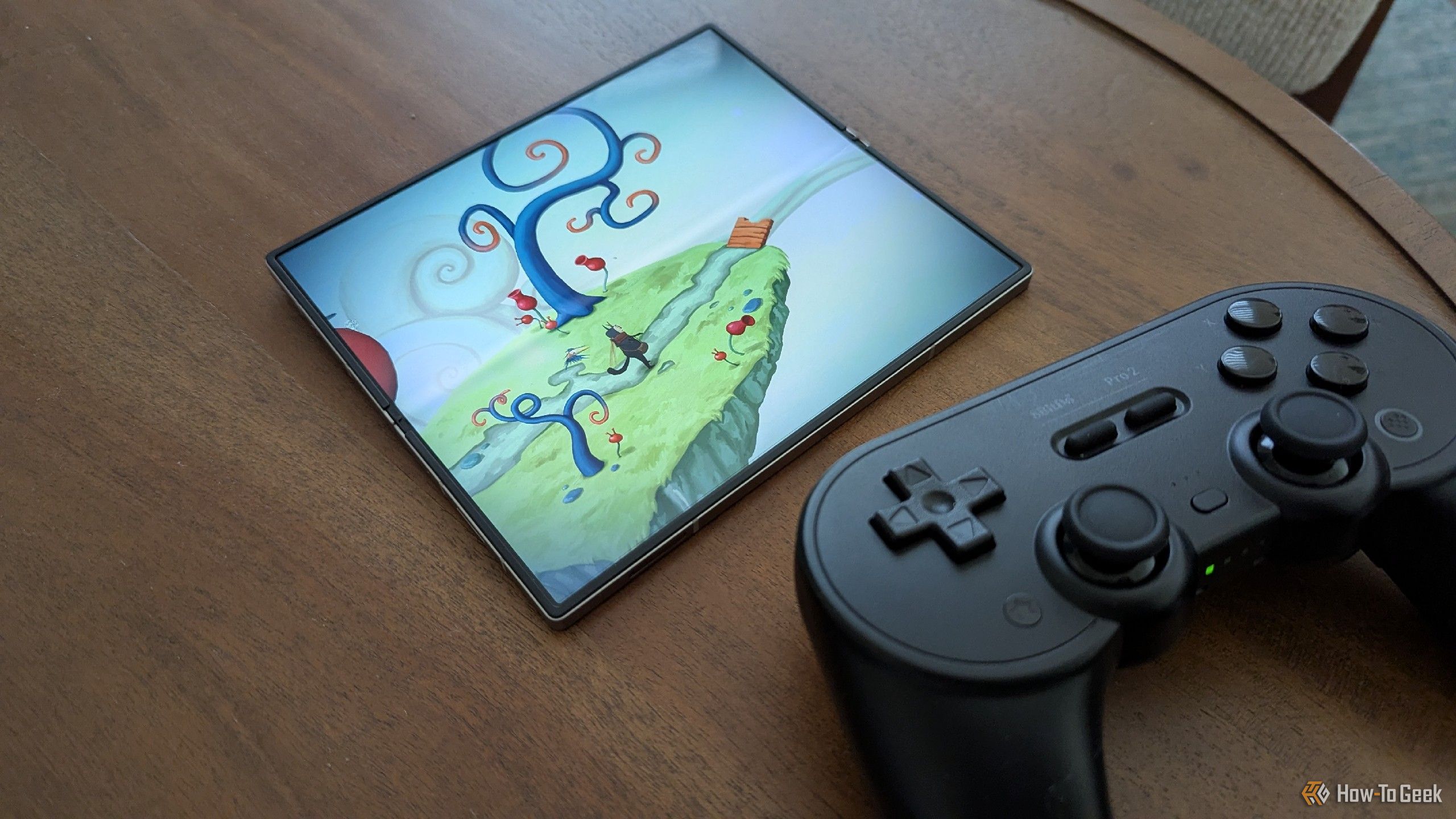 'Figment' in a Galaxy Z Fold 6 next to an 8BitDo Pro 2 controller.
