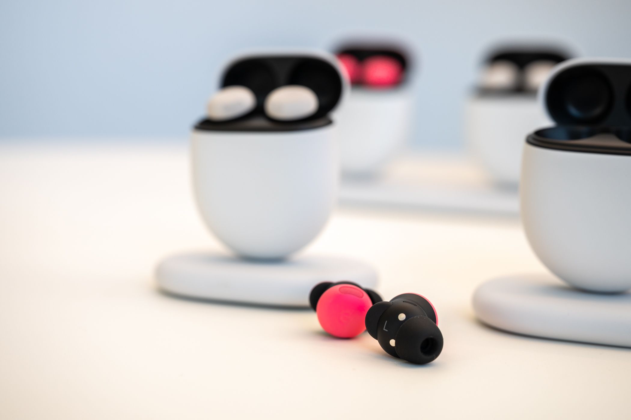 Google Pixel Buds Pro 2 in Peony sitting on a table outside of their charging case